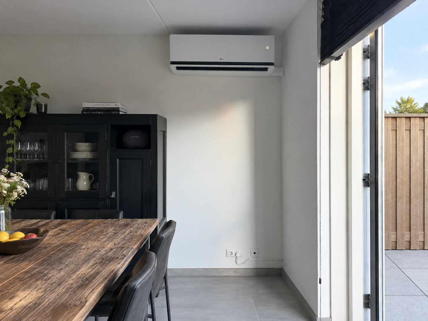LG-wandairco bij een eettafel en tuindeur